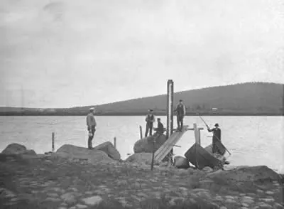 Vattenståndsmätning 1908. Svartvit bild. Män vid träställning i vattendrag. 