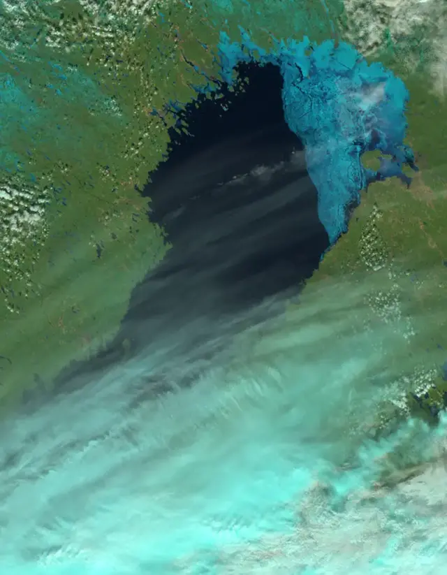 Isläget 19 april. Isen ligger i stort sett stilla i nordöstra Bottenviken fram till påsk. Milda sydvästvindar tar dock på kustisarna längre söderut och det blir helt isfritt upp till södra Bottenviken. Optisk bild, NOAA