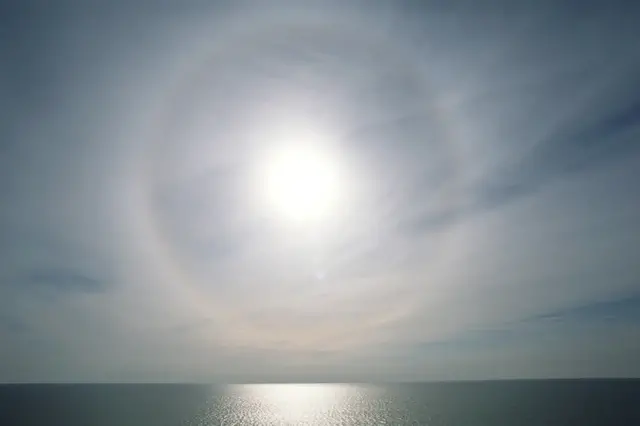 När solen skiner genom slöjmolnet, bildas en ljusring som kallas halo - detta syns i bilden.