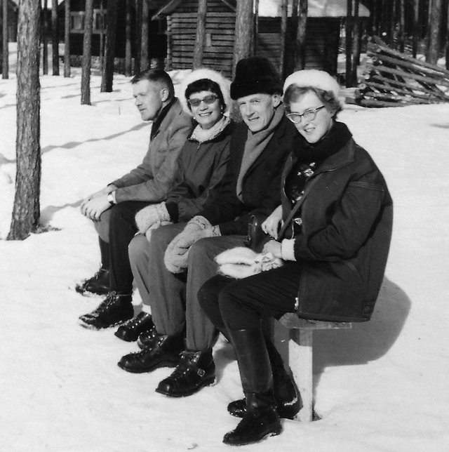 Fyra personer på bänk i snö och sol 1960-tal.